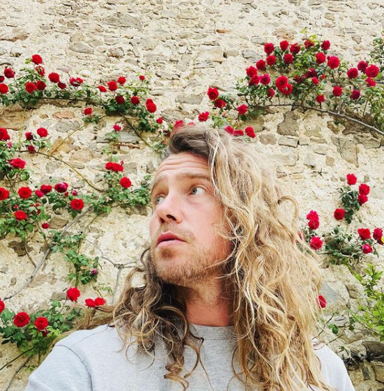 Julien Doré dans sa maison devant un mur de fleurs @Instagram
